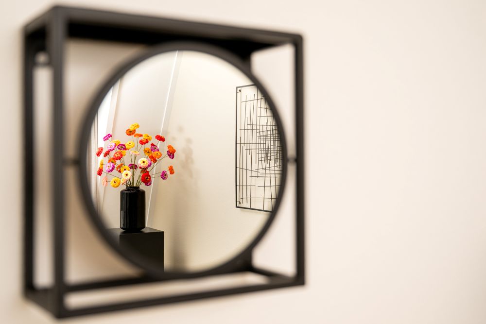 Bloemboeket weerspiegeld in een ronde spiegel in de massageruimte