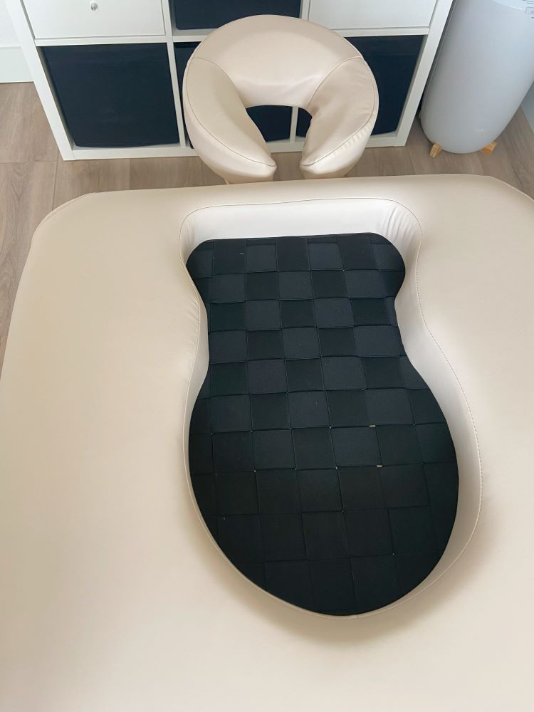 Massagetafel met uitsparingen voor buik en borsten.